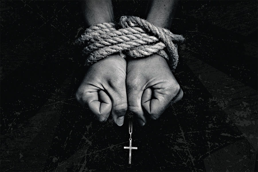 tied hands and a cross